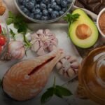 Bord met kleurrijke groenten, zalm en noten als voorbeeld van anti-inflammatoire voeding voor sporters