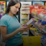 Iemand houdt een product beet in de supermarkt en leest de gezondheidsclaim